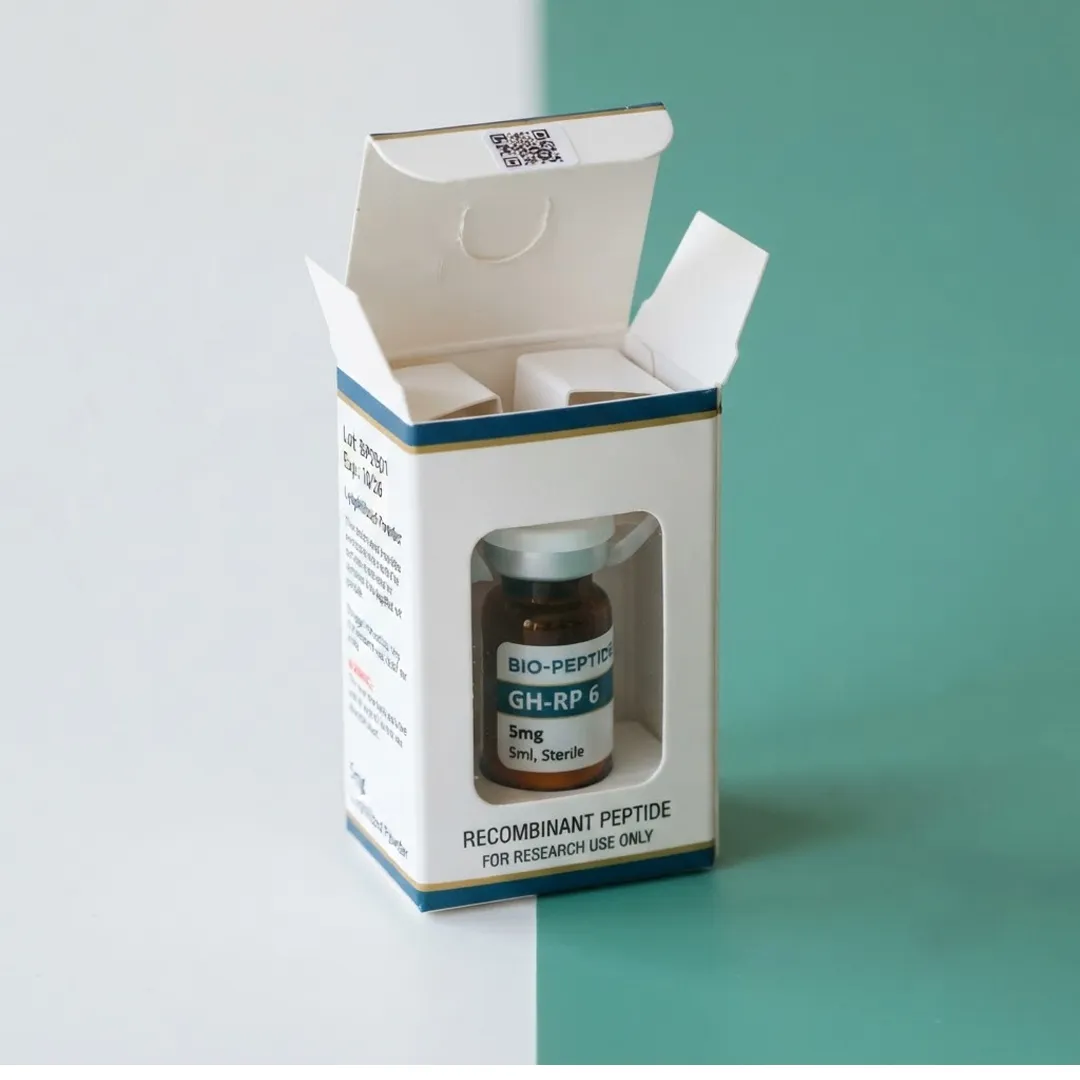 White tuck end carton with a die-cut window and QR code panel, opened to show a vial inside